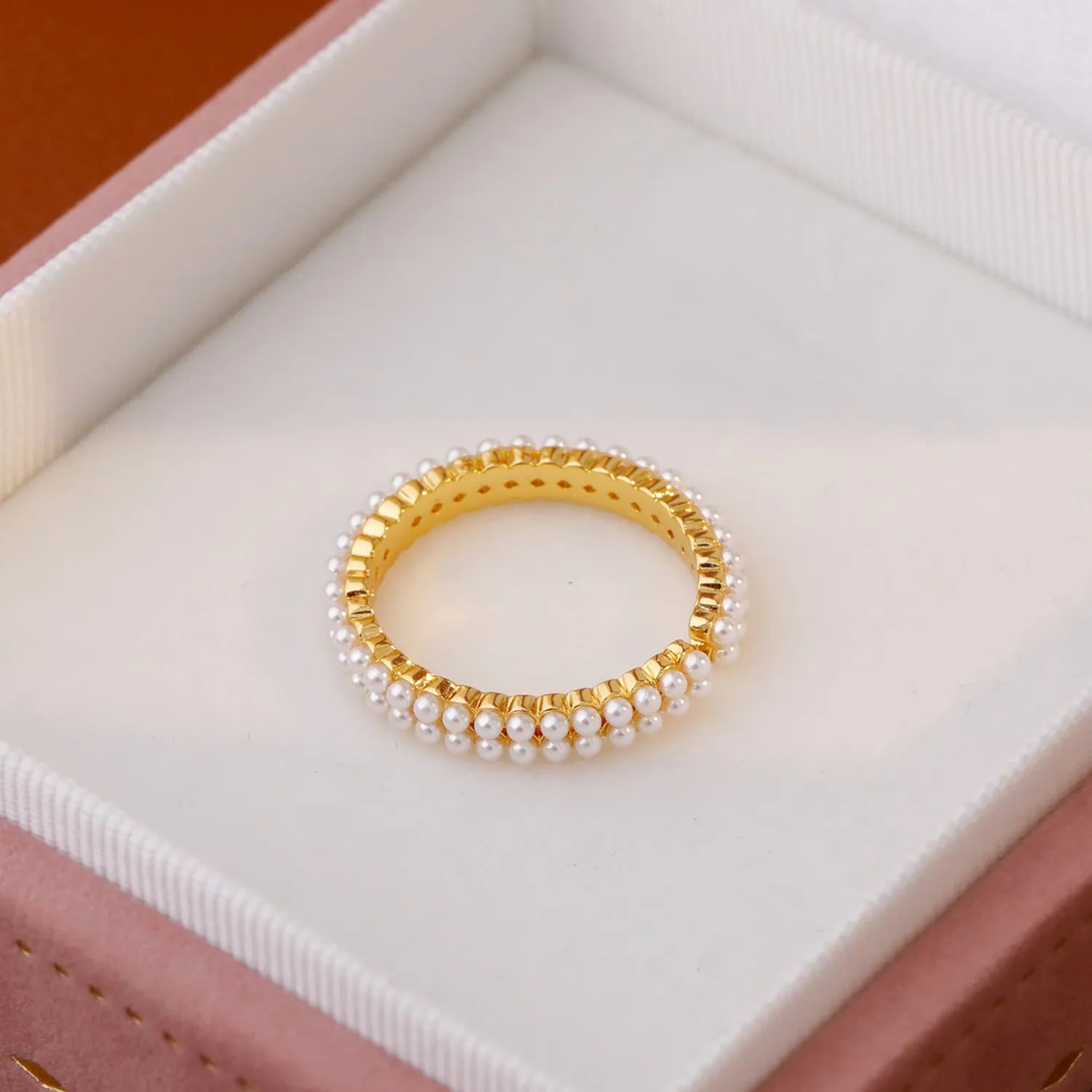 Gold coloured women's ring with open mouth design and round pearl elements on copper electroplated construction