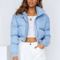 Women's loose blue polyester jacket with long sleeves on a hanger.