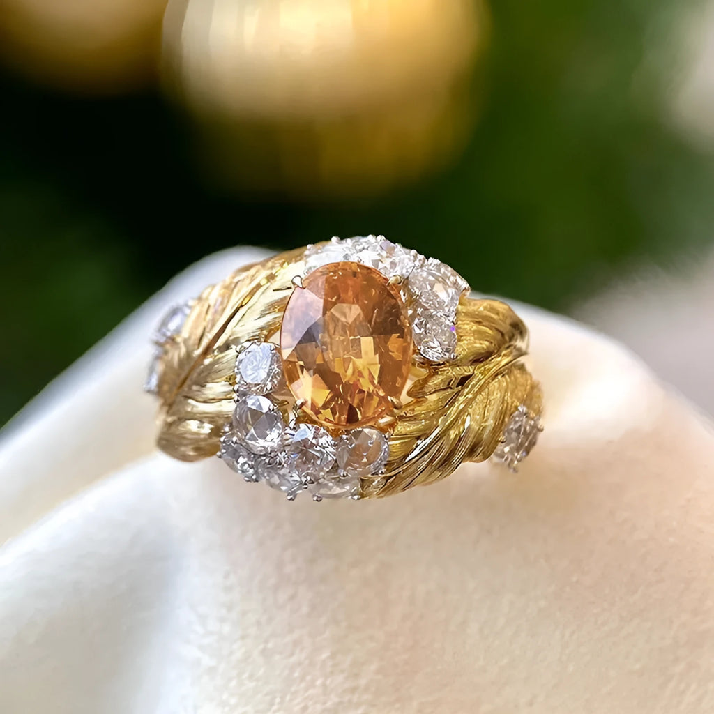 Gold-coloured copper ring with an embossed feather pattern and inlaid yellow zircon stones.