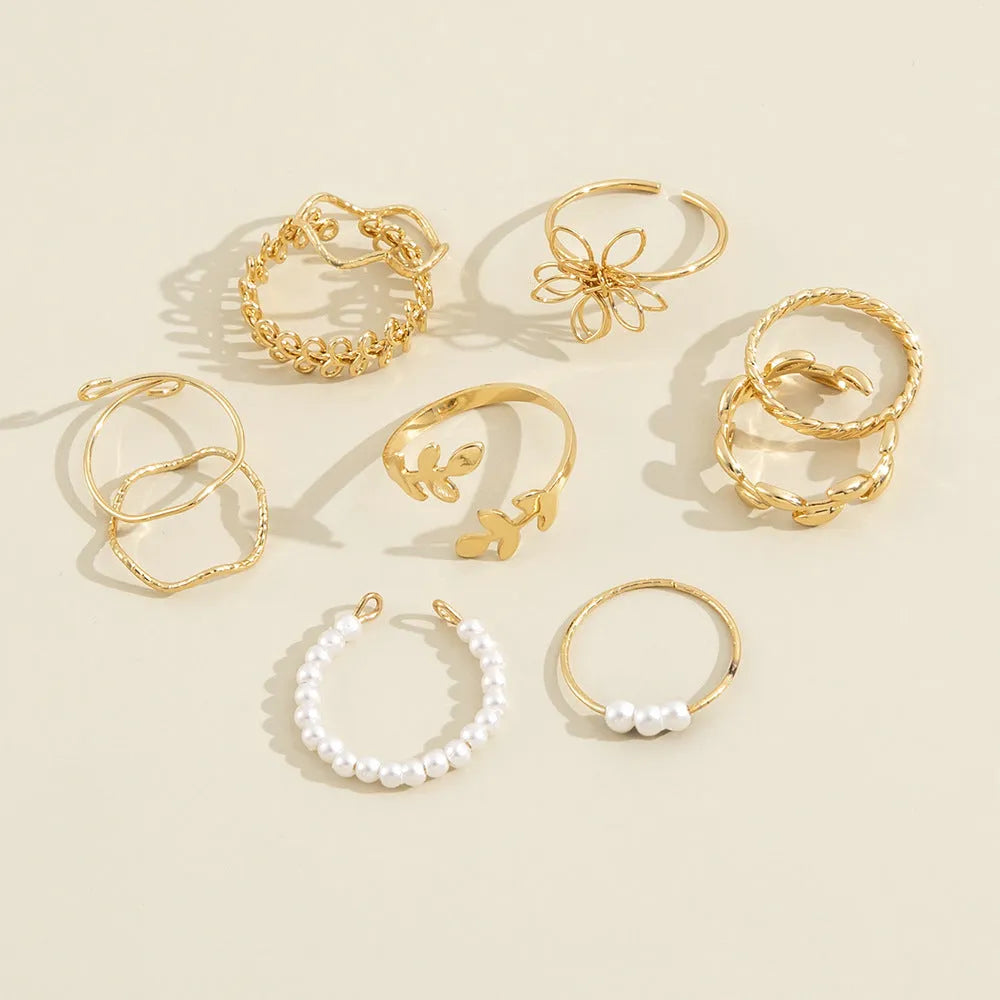 Gold tone openwork flower ring with intricate floral pattern design and glossy finish