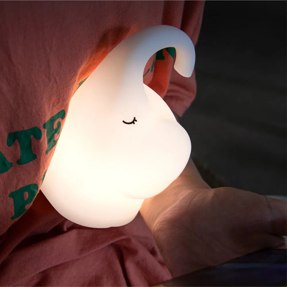 DOMI Elephant-shaped silicone night light in white with warm LED glow on a bedside table.