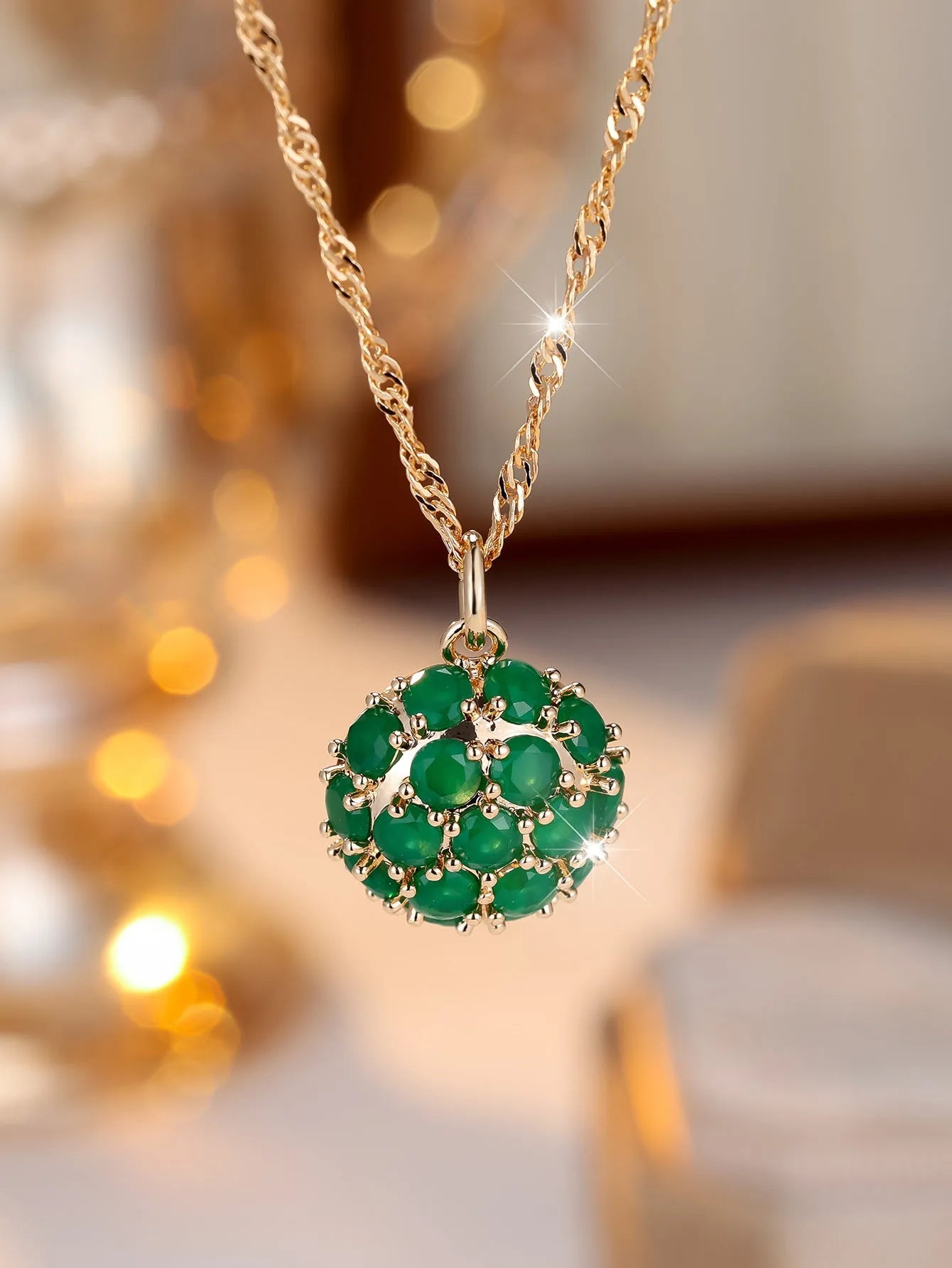 Round emerald pendant necklace with diamond setting on champagne gold chain
