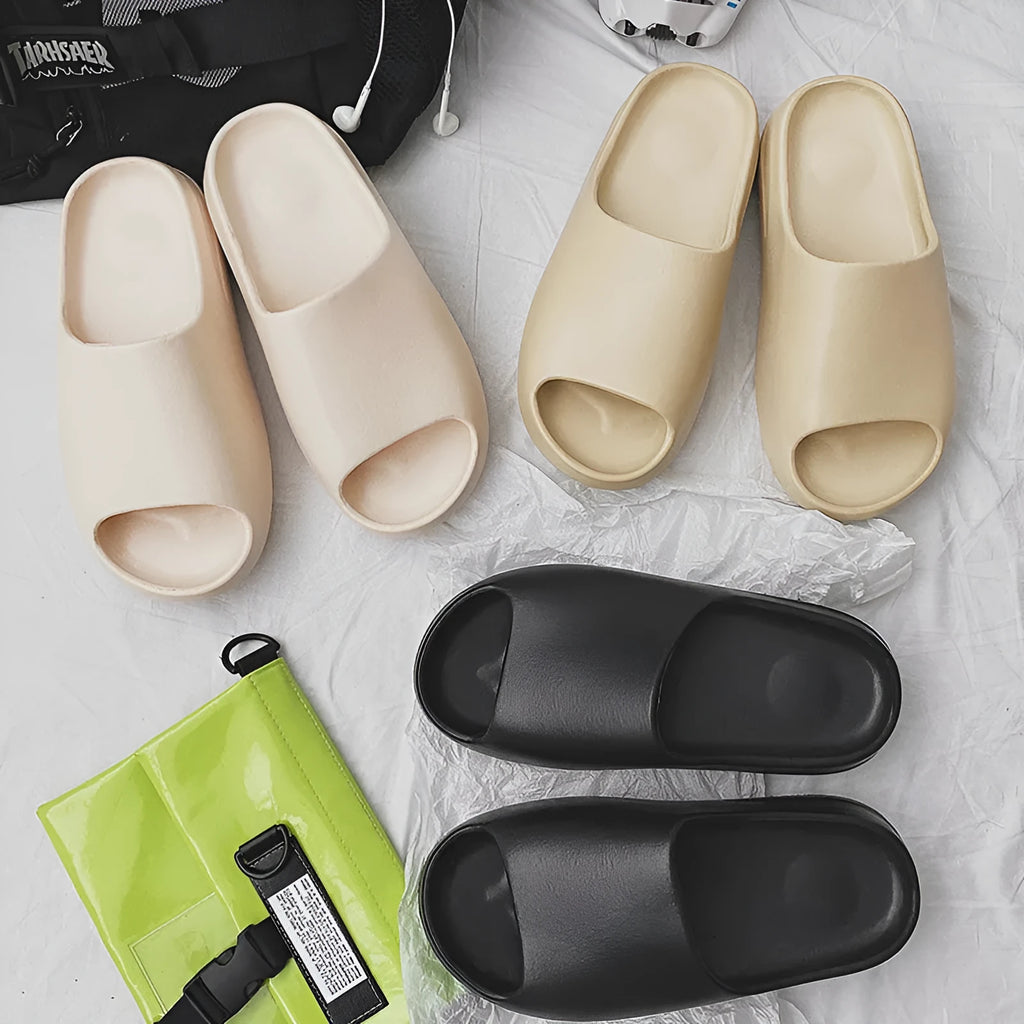 Women's thick-sole beach slippers in black, green, or brown on a sandy background.