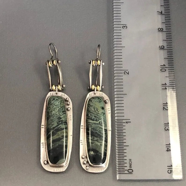 Geometric shaped drop earrings with a black and white marble pattern on an alloy metal backdrop.