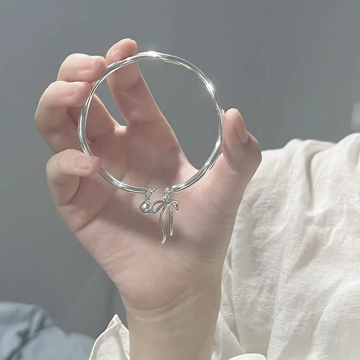 Silver adjustable women's bracelet with bow-shaped bell opening closure on zinc alloy chain
