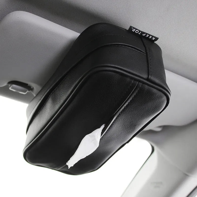 Black PU leather hanging storage box for car console organisation, shown with paper bag filler.
