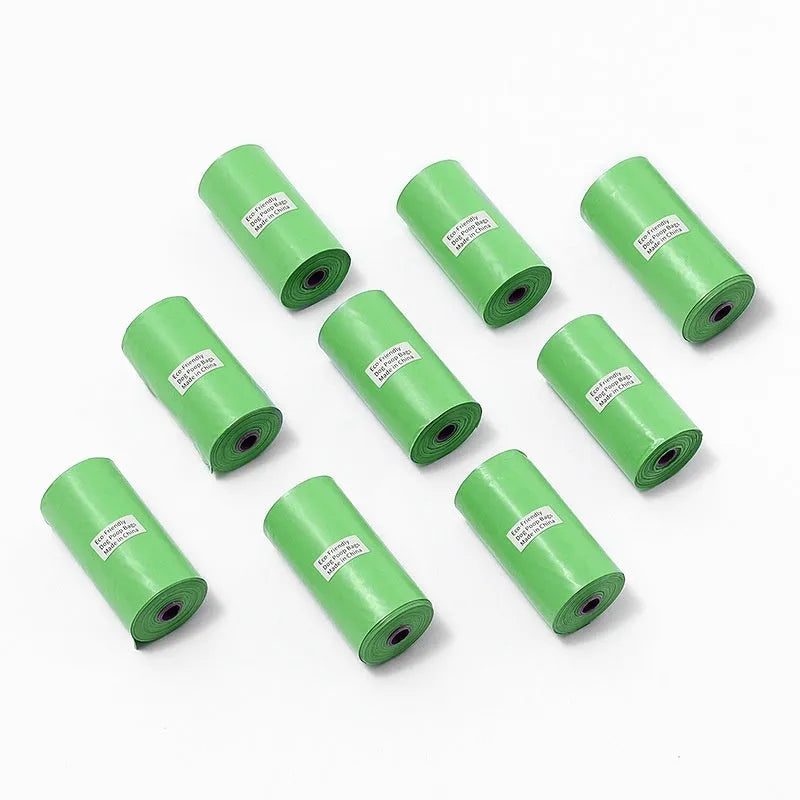 Roll of green EPI degradable pet garbage bags next to a boxed set with a dispenser.