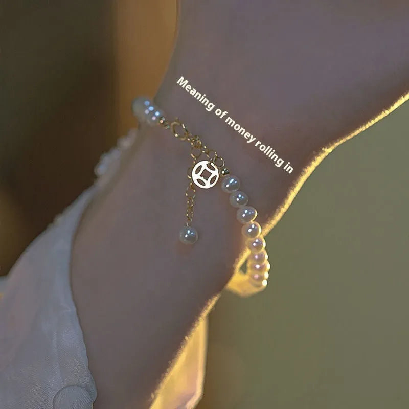 A Chinese style glass bracelet with bamboo leaf and bead designs on a wrist.
