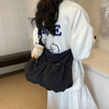Green pleated foldable polyester crossbody bag showing split pocket and internal phone compartment.