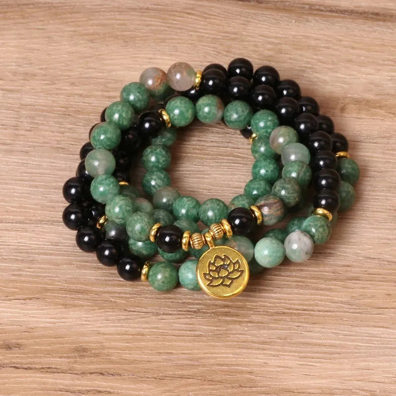 Green and black alloy bead elastic stretch bracelet on a wrist.