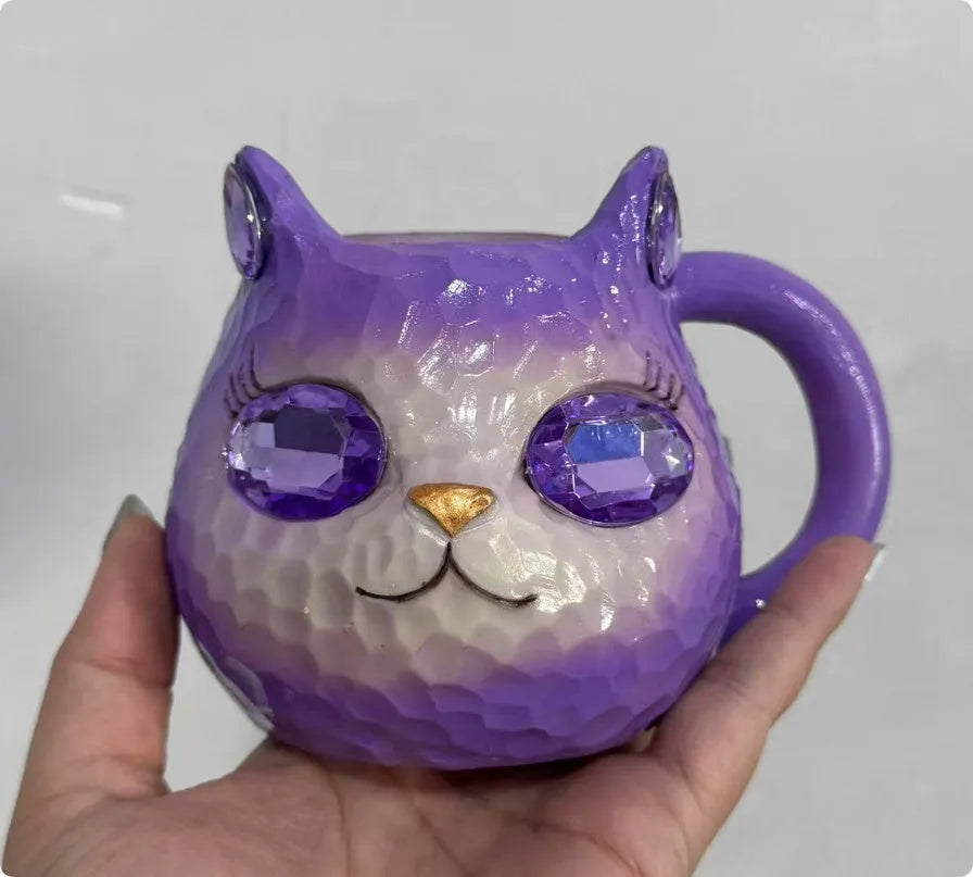 Small resin cat cup figurine in purple, green, blue, or pink colour on a shelf.