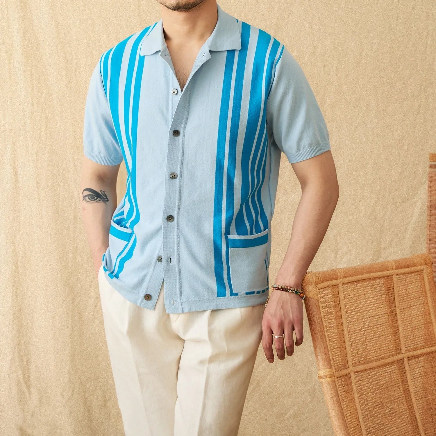 Man wearing a royal blue striped short-sleeved polo cardigan with a lapel collar.