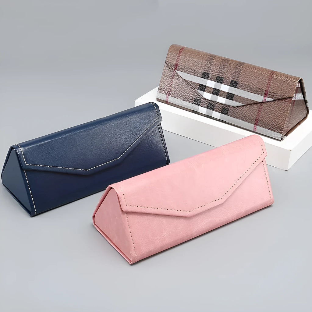 Handmade black PU cowhide triangular folding glasses case open next to a pair of spectacles.