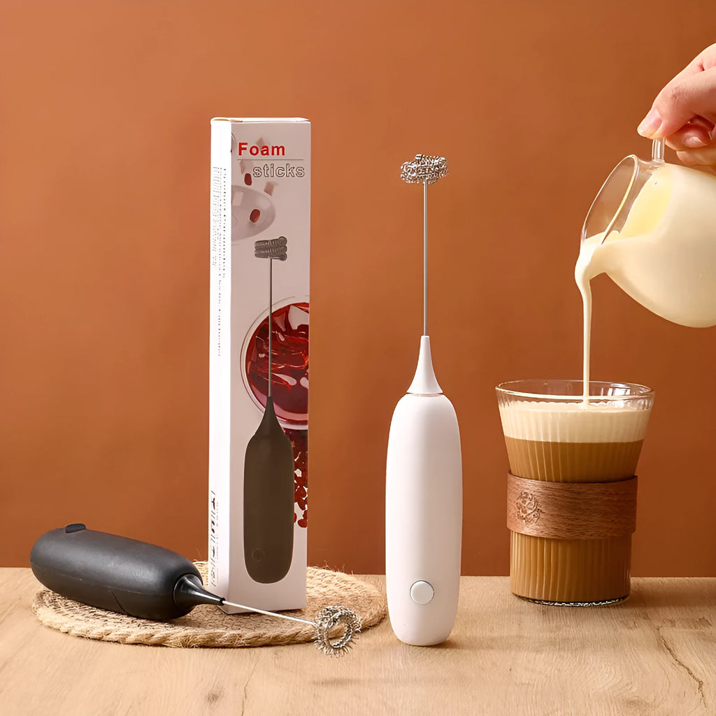 Black and white handheld electric milk frother with whisk attachment for coffee drinks
