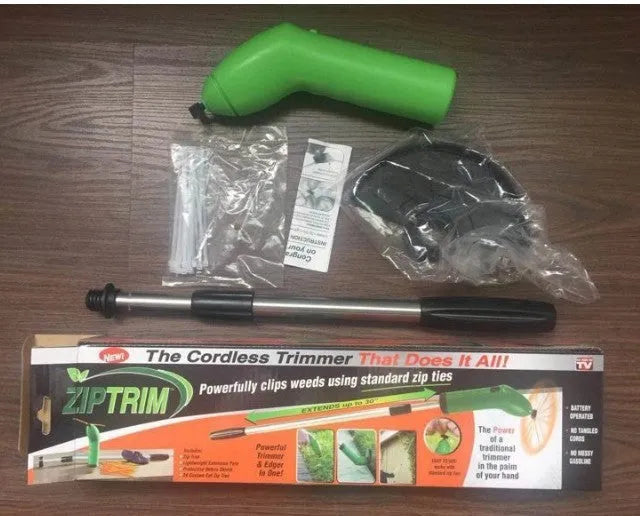 Cordless electric lawn trimmer with extension pole and black debris shield on a green lawn.