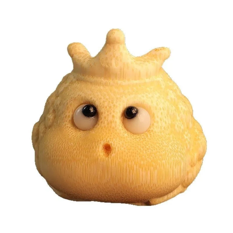 Close-up of a hand-carved bamboo Crown Princess toad ornament with live eye detailing.