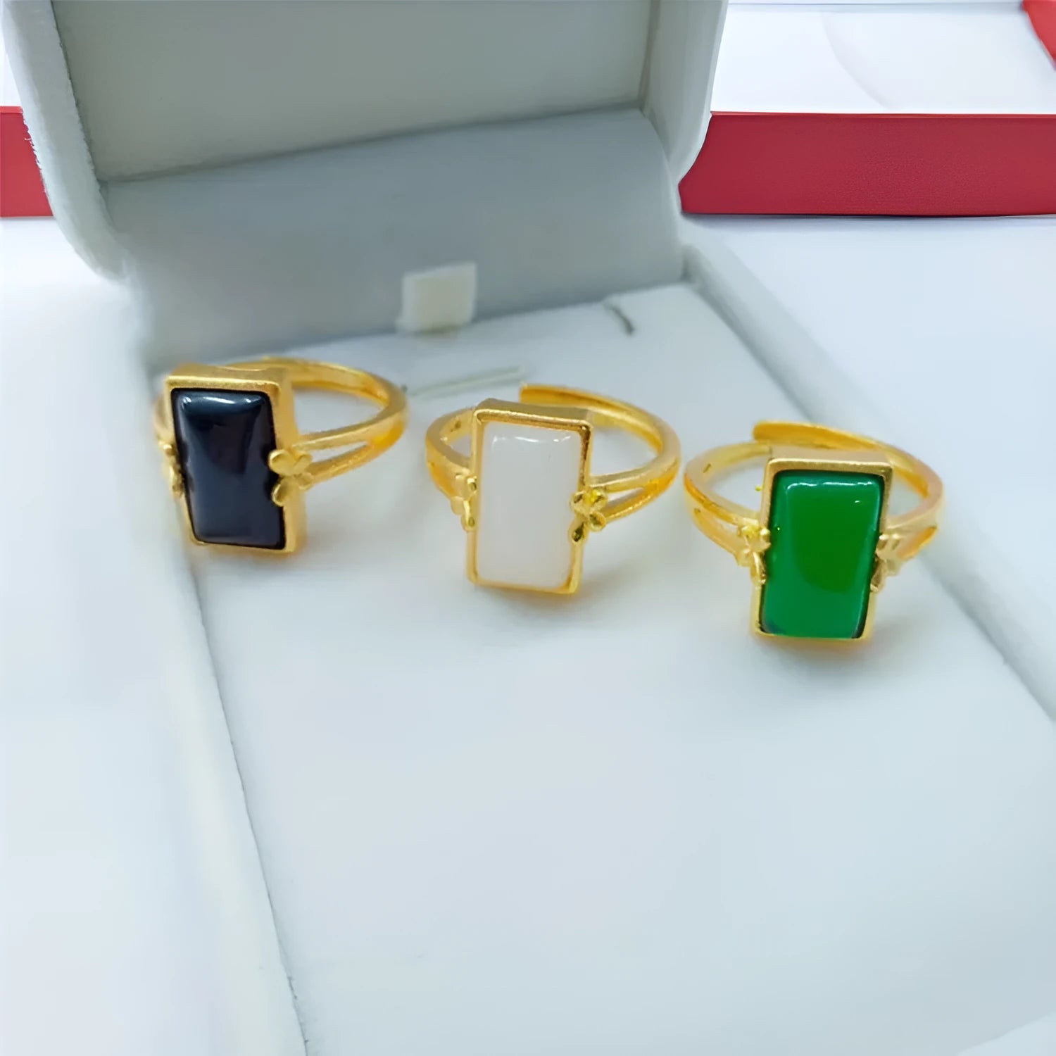 Adjustable brass gold-plated ring with an electroplated finish and a choice of black, green, or white gemstone.