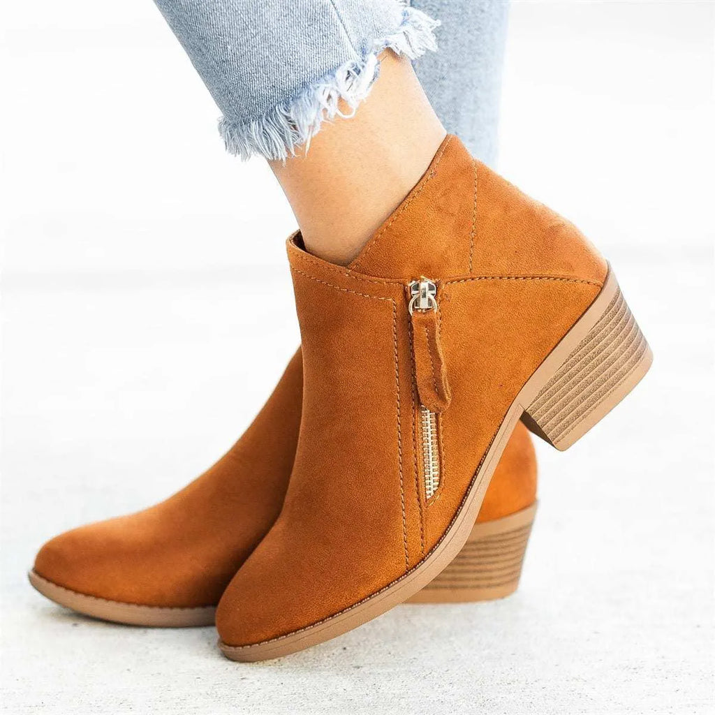 Women's blue suede ankle boots with a side zip and chunky heel, shown on a foot.