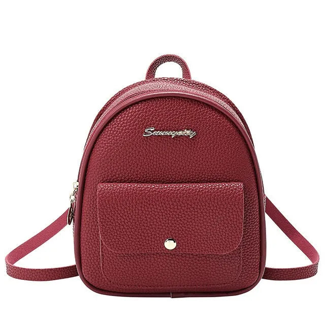 Small black PU women's backpack with zipper, shown alongside a mobile phone for scale.
