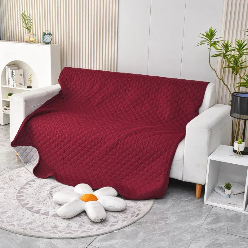 Reversible waterproof dog blanket on sofa showing two colour options with multiple size measurements