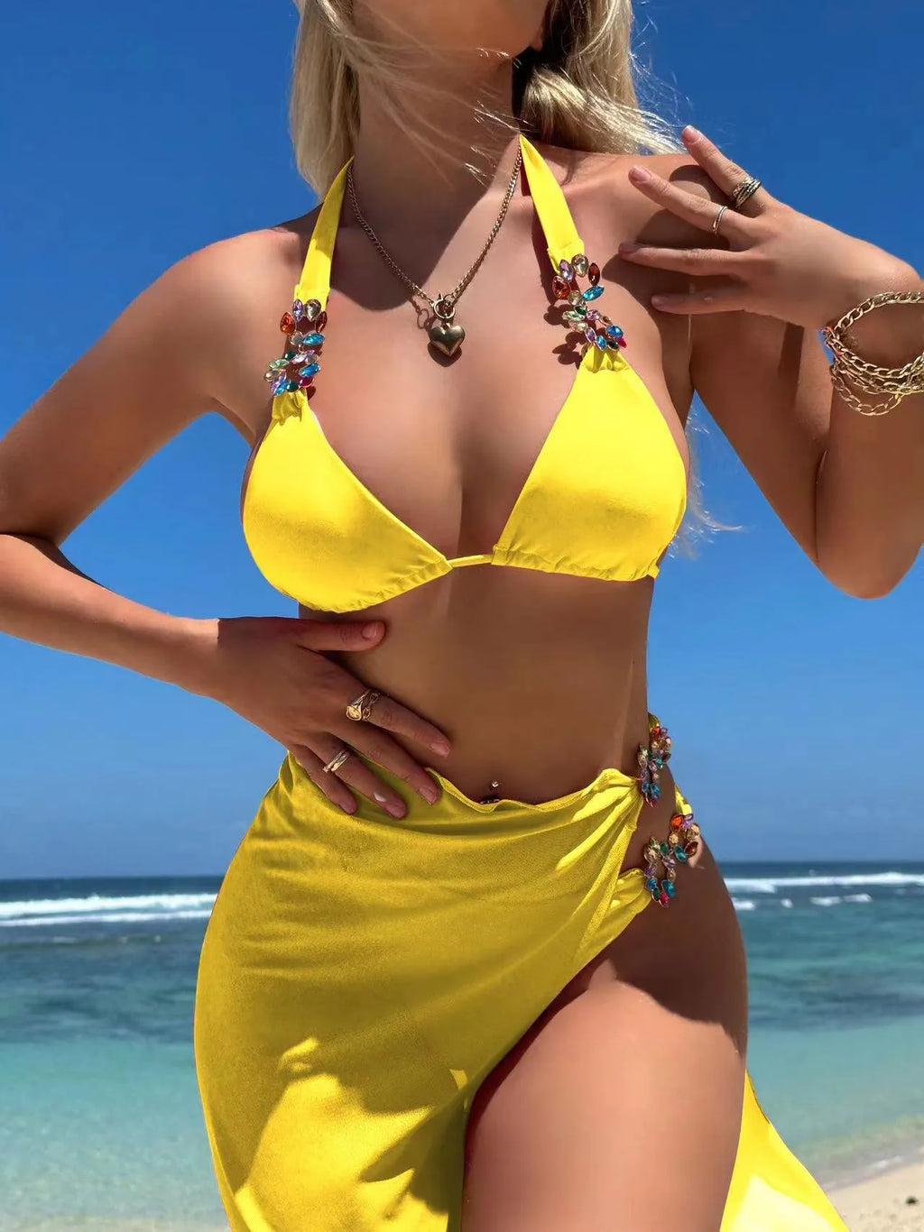 Rose red and yellow three-piece swimsuit bikini set with a mesh skirt laid flat.