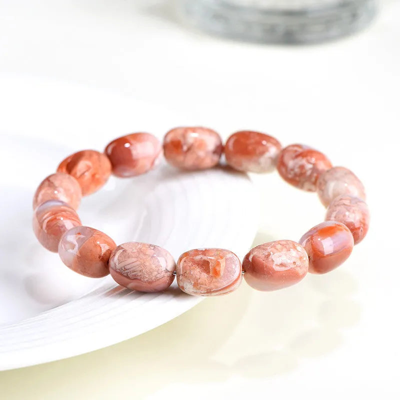 Natural cherry agate barrel bead bracelet with Ruyi design elements on wrist