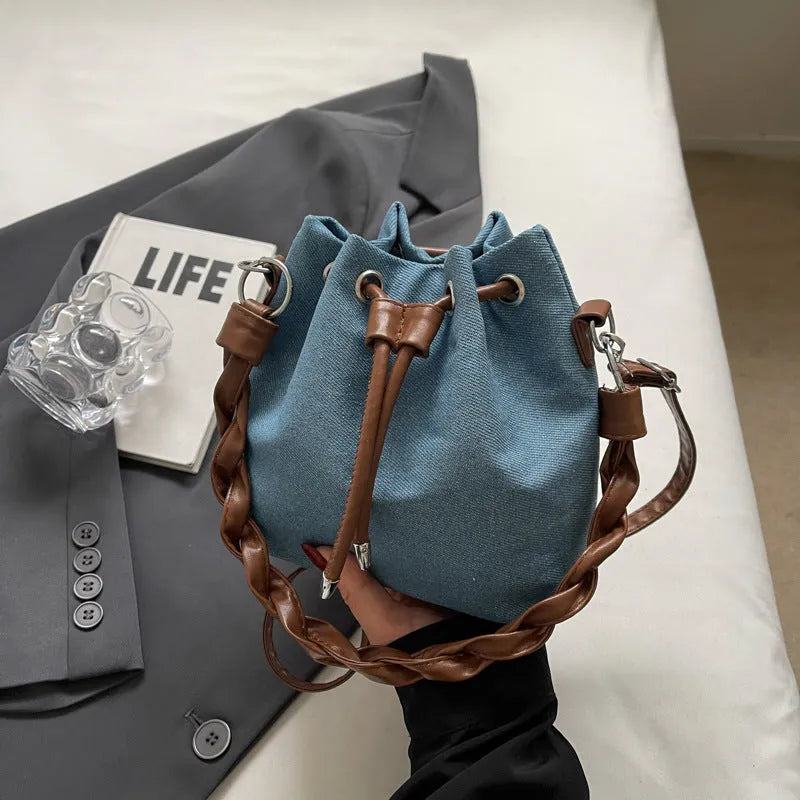 Blue synthetic leather cross-body bucket bag with adjustable strap and optional hanging drop decoration