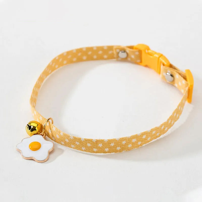 Green adjustable cat collar with a silver bell and a matching bow tie on a white background