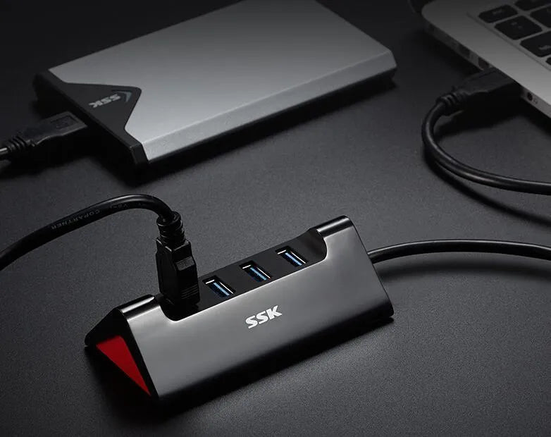Black ABS plastic USB expansion hub with 4 ports and a Micro USB power port, shown with a connecting cable.