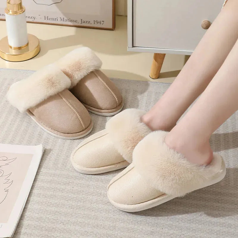 A pair of plush fur-lined indoor slippers with a round toe and a flat PVC sole.