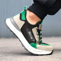 Low-top black green safety overshoe with plastic steel toe cap, showing microfiber leather and flyknit mesh upper construction.
