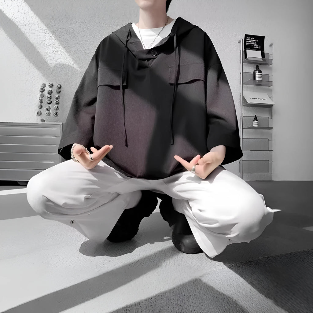 Man wearing a loose fit black hooded short sleeve t-shirt for summer.