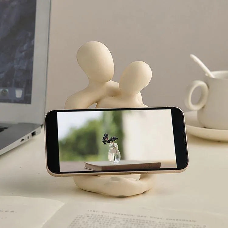 Modern milky white loving couple resin statue displayed on a wooden desk