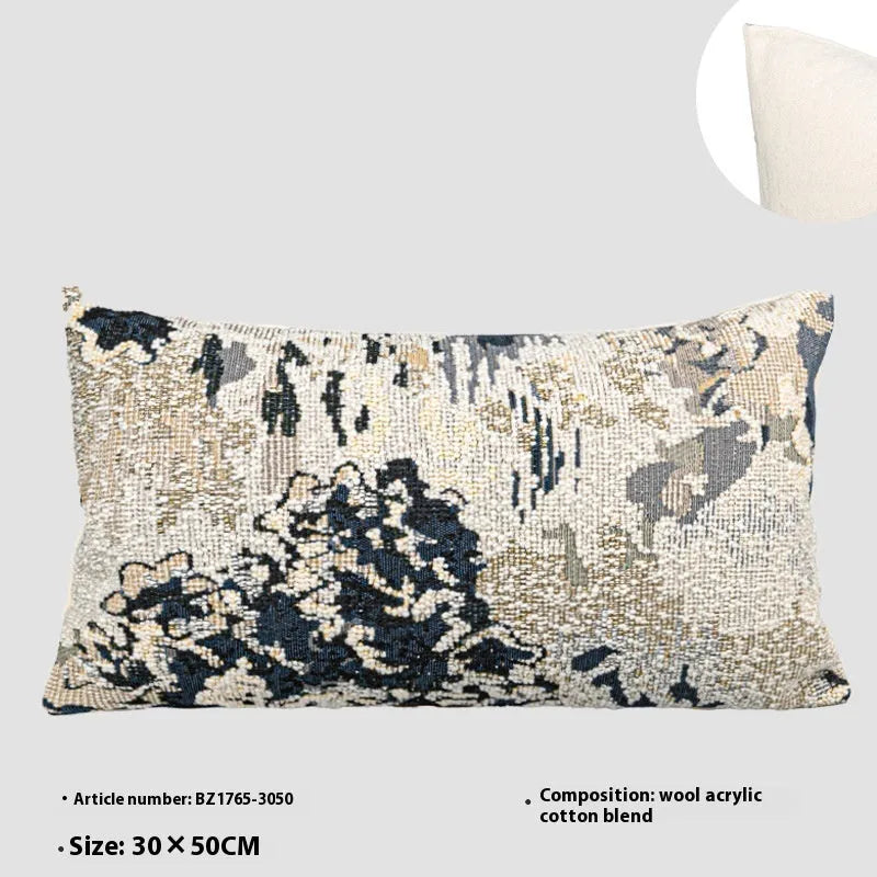 Antique blue French style decorative pillow with abstract floral pattern on a sofa.