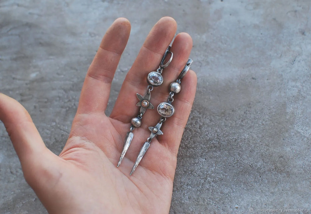 Geometric long pendant earrings with antique silver plating and rhinestone details on an XINGX design.