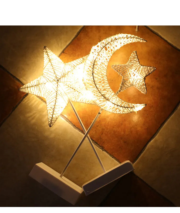 Rattan and copper wire LED table lamp in a star shape on a bedside table.