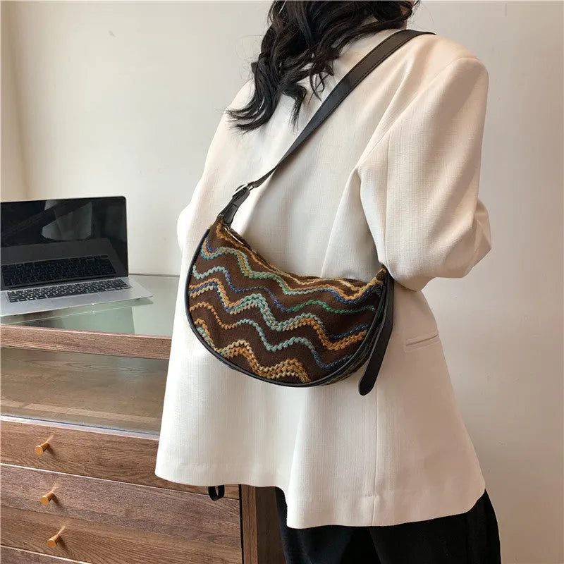 Women's woven straw crossbody bag showing internal phone and document compartments