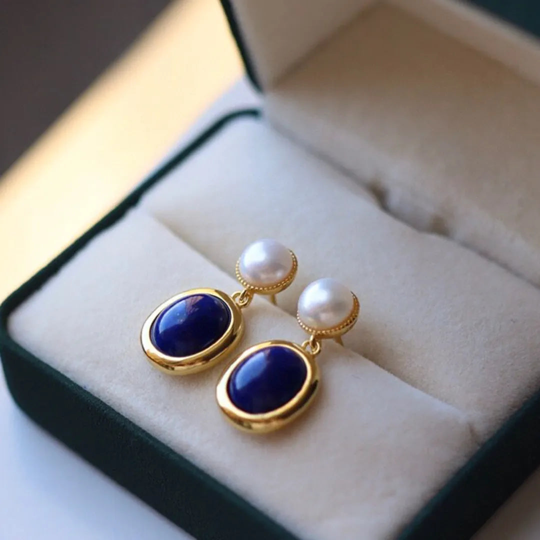 A pair of simple stud earrings featuring a deep blue lapis lazuli pearl set in 925 silver.