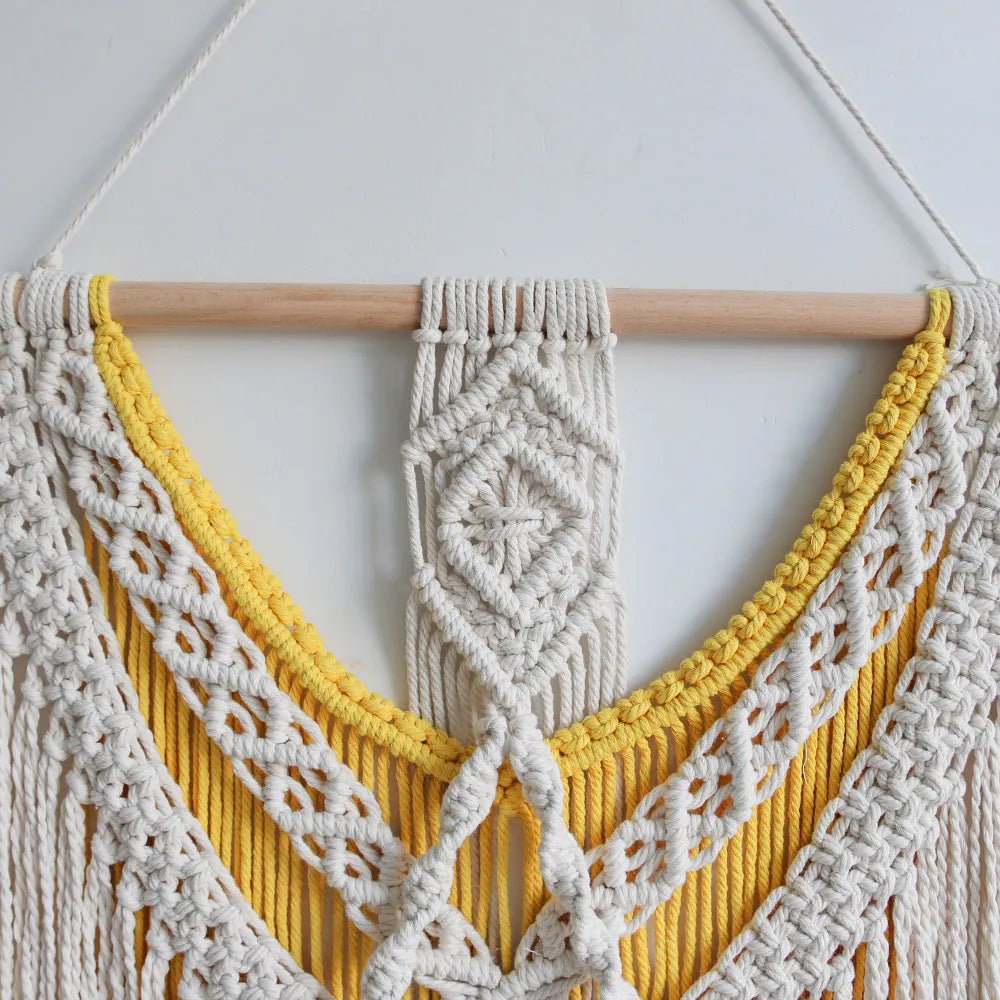 Hand-woven creamy white and yellow Nordic style cotton tapestry hanging on a wall