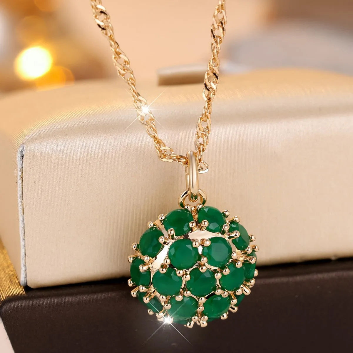 Round emerald pendant necklace with diamond setting on champagne gold chain