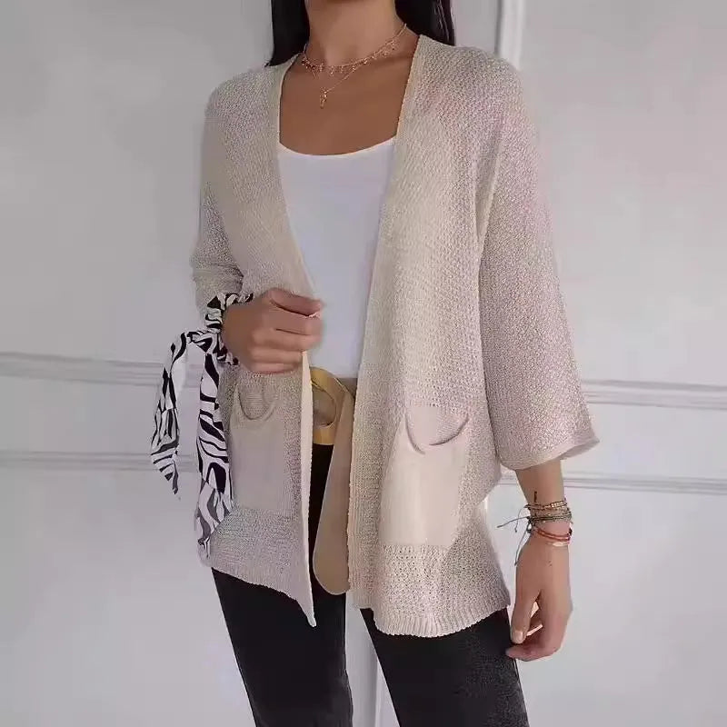 Women's army green waffle knit cardigan coat with nine-quarter sleeves and pockets laid flat.