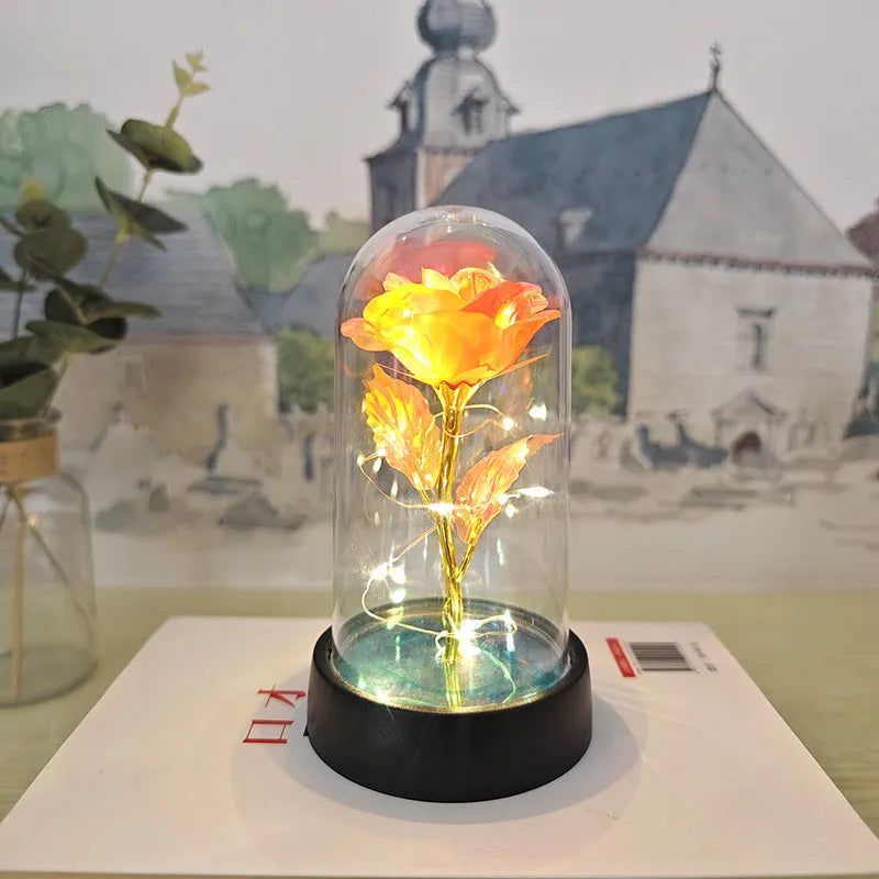 Small plastic night lamp with glass cover showing coloured flowers inside on black base