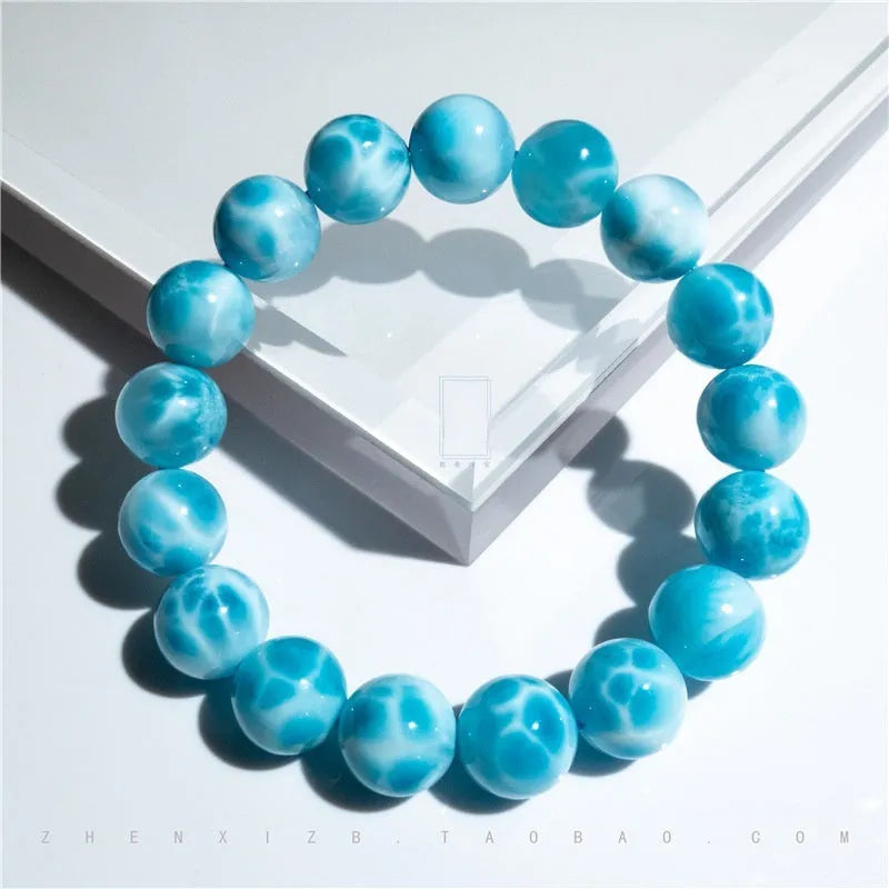 Blue natural crystal sea-pattern stone and bodhi seed bracelet with pearl accents on a wrist.