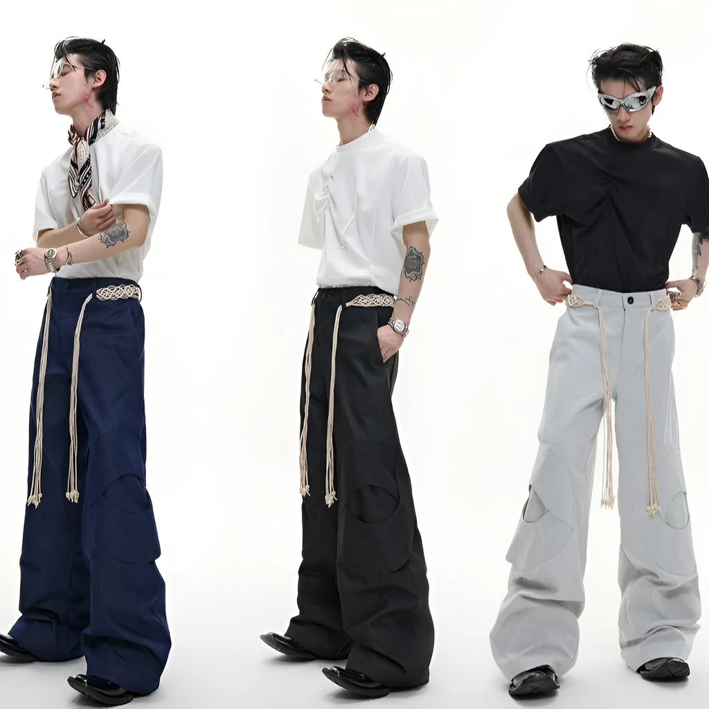Men's dark blue loose-fit straight-leg cotton trousers with zipper decoration and tassel detail.