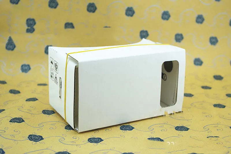 Pink and white VR cardboard glasses viewer for smartphones with adjustable head strap.
