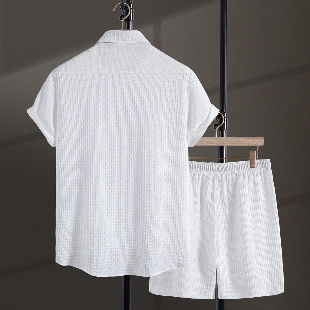 Men's loose-fitting cotton blend short sleeve shirt and shorts suit in black, laid flat.