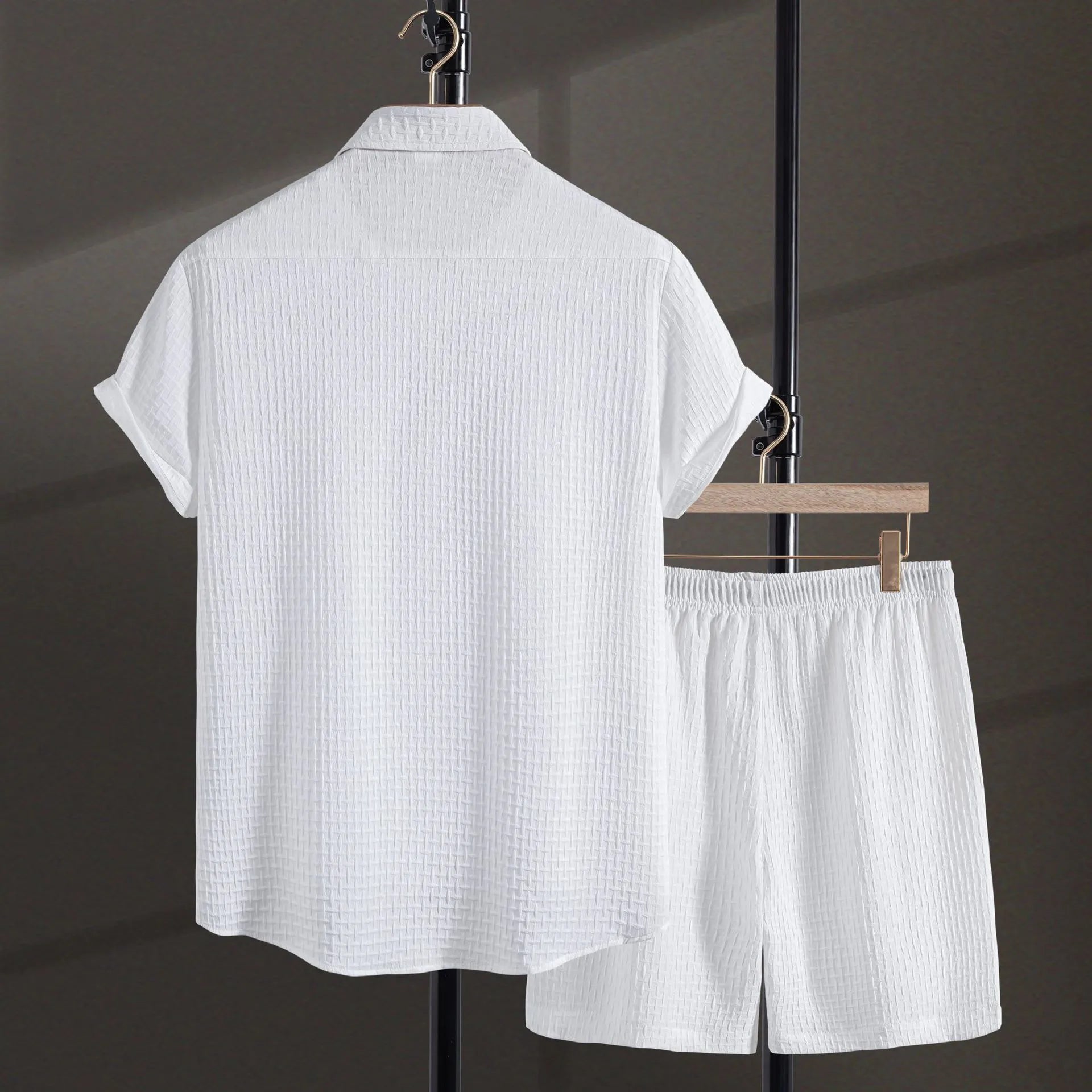 Men's loose-fitting cotton blend short sleeve shirt and shorts suit in black, laid flat.