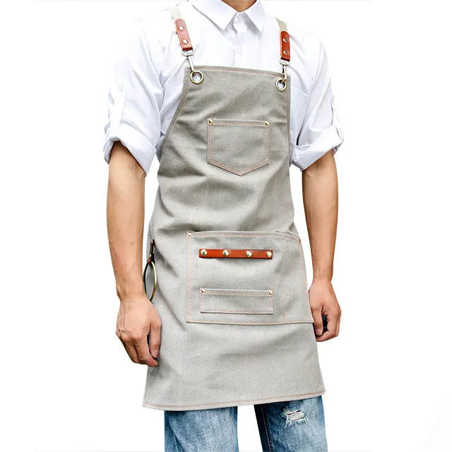 Canvas cross-back apron in camel colour on a mannequin, showing adjustable neck and waist ties