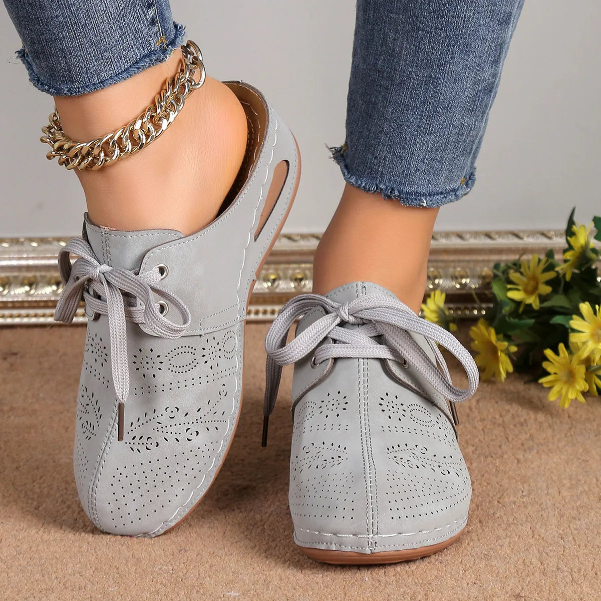 Women's black lace-up wedge slippers with a suede upper and hollow-out rubber sole on a light background.