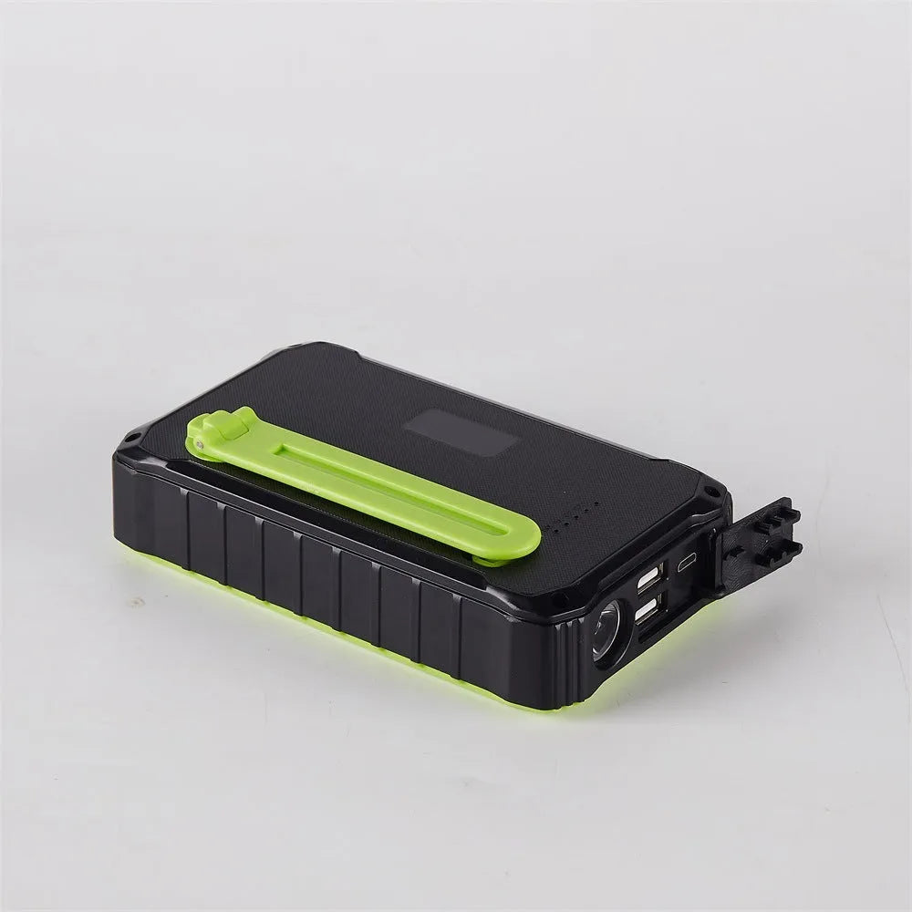 Orange and green hand-crank solar power bank with LED torch and dual USB ports showing 12000mAh capacity